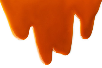 Background of flowing caramel sauce isolated on white.