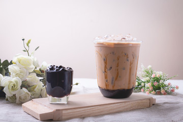 bubble tea in plastic cups on a wooden plate.