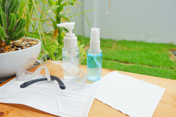 Sanitizer gel, alcoholic gel spender and protective masks with protective glasses. Covid19 prevention kit.Close up.
