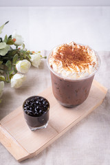 bubble tea in plastic cups on a wooden plate.