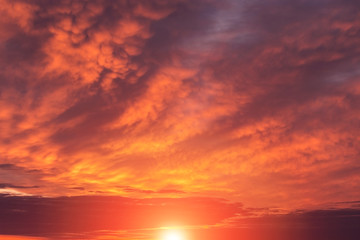 Naklejka na ściany i meble Epic dramatic sunset, sunrise red orange sky with mammatus clouds, sun and sunlight