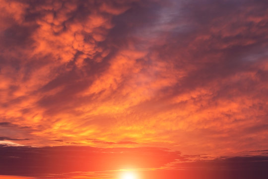 Epic dramatic sunset, sunrise red orange sky with mammatus clouds, sun and sunlight © Viktor Iden