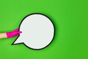 Hand in pink protective rubber glove with comment isolated on green studio background with copyspace. Gesturing, holding, presenting things. Negative space for your advertising. Showing, pointing.