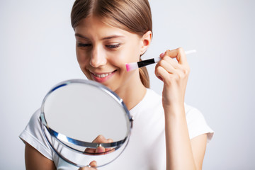Woman face skin cosmetics, woman in front of a mirror applies a cream for skin care