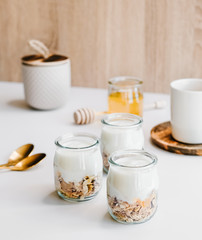 Healthy breakfast set with coffee, homemade yogurts with granola, honey or agave syrup.