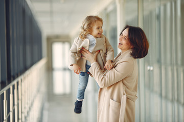 Mother with daughter. Family in hall. Woman in a brown coat.