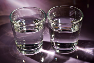 Glasses with alcohol close up. Vodka on a purple background.