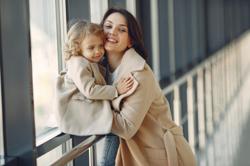 Mother with daughter. Family in hall. Woman in a brown coat.