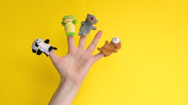 Animals zoo puppet dolls theater. Hand wearing finger puppets: elephant, frog, dog, rabbit, hippo, bear, panda. animal finger puppets show isolated. quarantine fun. One finger left empty. Loniliness
