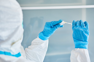 Medic holds throat swab for saliva sample during coronavirus test