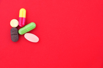 A few different tablets and capsules on an isolated bright background. Concept of medical treatment.