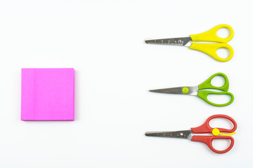 Scissors and writing paper in pink color isolated on a white background.