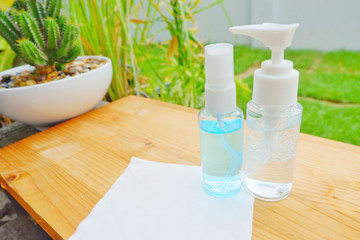 Alcohol gle and a white cloth on wood shelf.Alcohol gel bottle for protect bacterial and anti virus (COVID19).Close up.