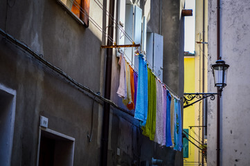 Washed clothes hanging outside the windows in the street of Chioggia, near Venice in Italy.