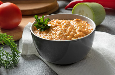 ceramic bowl with cream soup on the background of cutting boards and vegetables