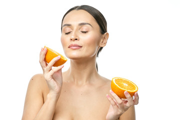 Close up beauty portrait of an excited attractive half naked woman holding orange slices at her...