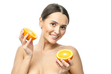 Close up beauty portrait of an excited attractive half naked woman holding orange slices at her...