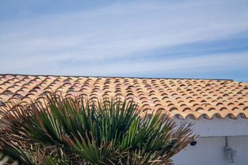 Roof with blue sky with classic terracotta tiles.