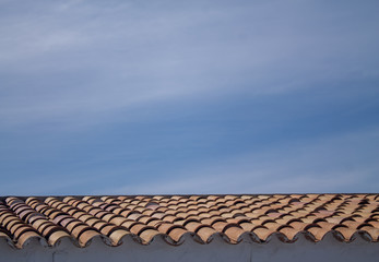 Roof with blue sky with classic terracotta tiles.