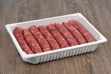 Saucisses de porc crues dans leur emballage en gros plan