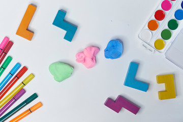 felt-tip pens, cubes, paints and plasticine on a white background. children's desktop. School, education and learning concept. creativity for kids. Top view colorful background. Flat lay