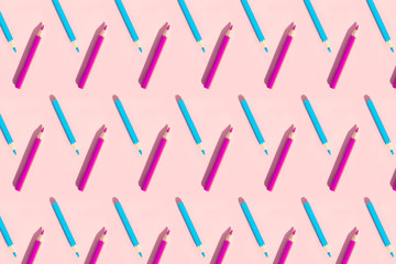 Pattern of colorful pencils. Bright pink and blue pencils on pastel pink background. Back to school, education and learning concept. Minimalist concept.