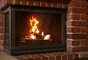 Fireplace with burning wood indoors. Winter vacation