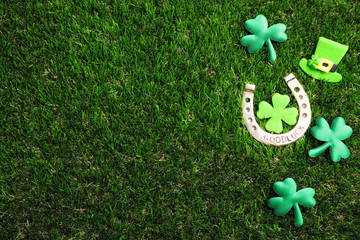 Flat lay composition with horseshoe on grass, space for text. St. Patrick's Day celebration