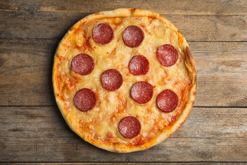 Tasty pepperoni pizza on wooden table, top view