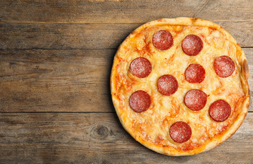 Tasty pepperoni pizza on wooden table, top view. Space for text