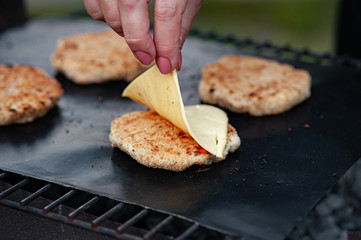 Putting cheese on a cutlet. Grilled Burger Cutlet