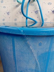 water overflowing from the blue bucket