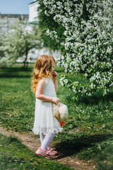 portrait of a little red-haired girl in Apple trees