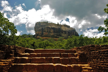 Unique Lion Mountain - Sigiriya. Ancient stone steps lead through the jungle to an impregnable rock fortress. Against the sky, a majestic rock looks amazing.