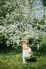 portrait of a little red-haired girl in Apple trees