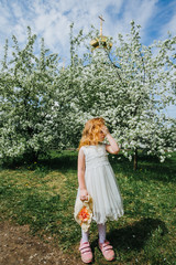 portrait of a little red-haired girl in Apple trees