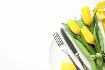 Festive Easter table setting with floral decor on white background, top view