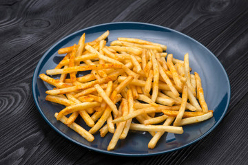 french fries on a blue plate and black background
