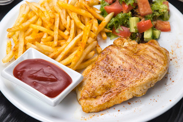 chicken, french fries, sauce on a white plate