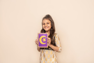 Small girl wearing traditional pakistani dress and celebrating Ramadan Kareem.