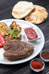 grilled steak, zucchini, on a white plate and black background