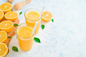 Orange juice in glass, fresh fruits on wooden background