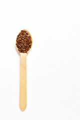 Flax and sesame seeds in wooden spoons on white background. View from above.