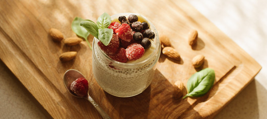 Chia seed pudding with berries on wooden background. banner for website