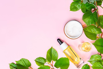 Fototapeta na wymiar Skin care products, natural cosmetic. Flat lay image on pink background. Natural cosmetic skincare bottle, serum and organic green leaf. Homemade and beauty product concept.