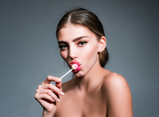 Woman with red lips licking lollipop. Beautiful young woman with clean fresh skin. Sensual woman....