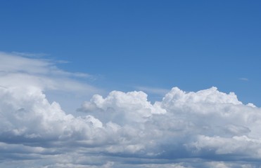 Naklejka na ściany i meble Aerial view on moody thunder clouds flying on horizon under blue sky