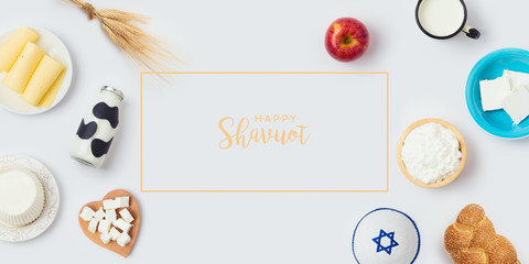 Jewish holiday Shavuot banner design with milk bottle, cheese and bread on white background. Top view from above