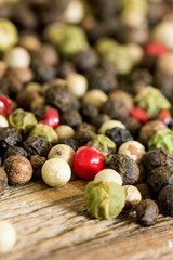 Soft focus photo of mixed peppercorns. Spices on wooden background.