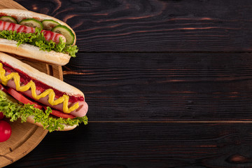 Hot dogs on wooden background. Top view with copy space. Fast food concept